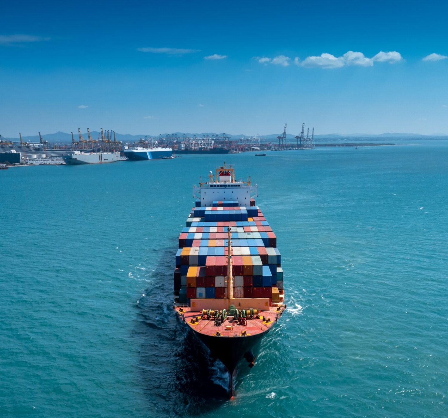 Aerial in front of cargo ship carrying container and running for export  goods  from  cargo yard port to custom ocean concept freight shipping by ship .